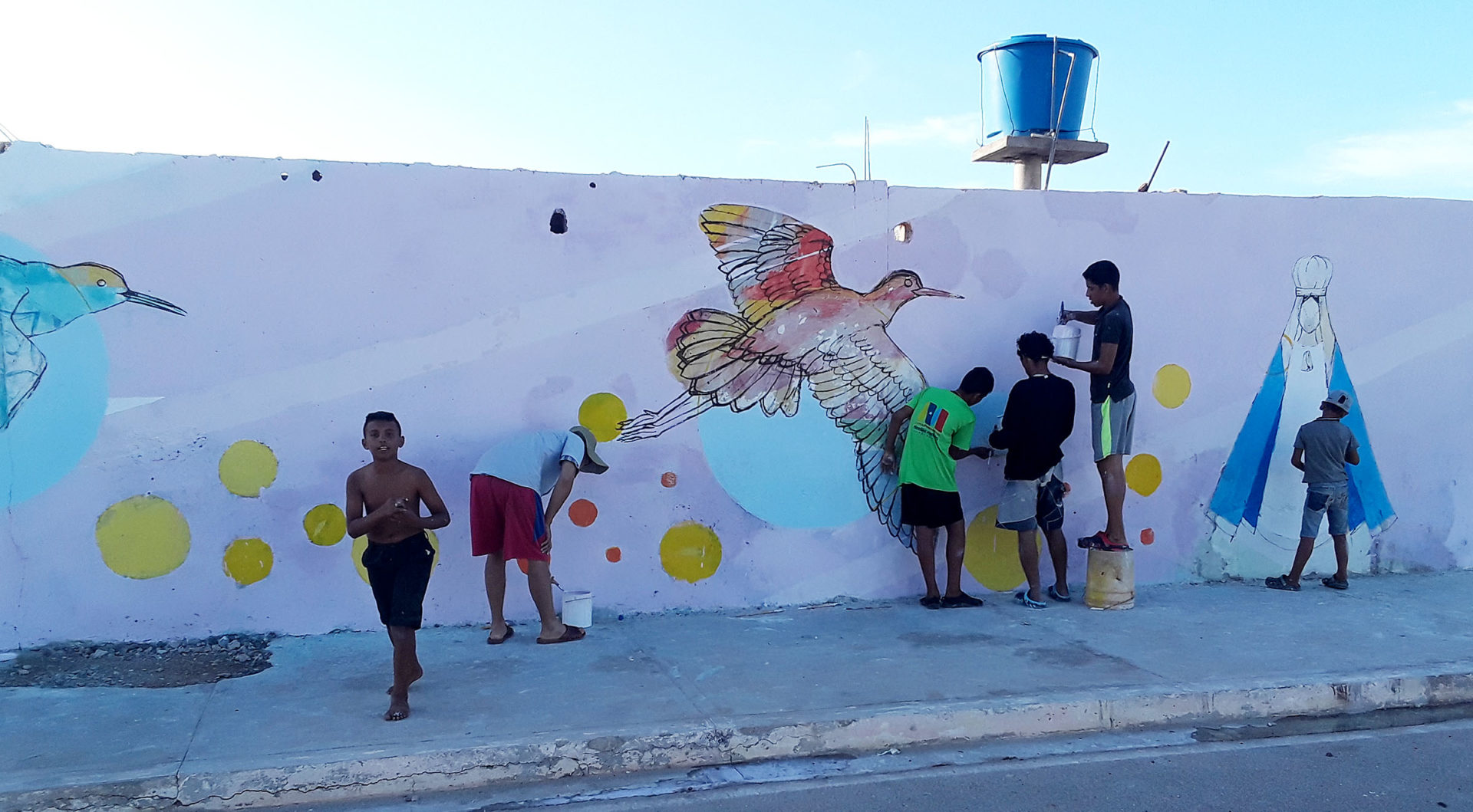 Children painting mural with birds in Isla de Coche